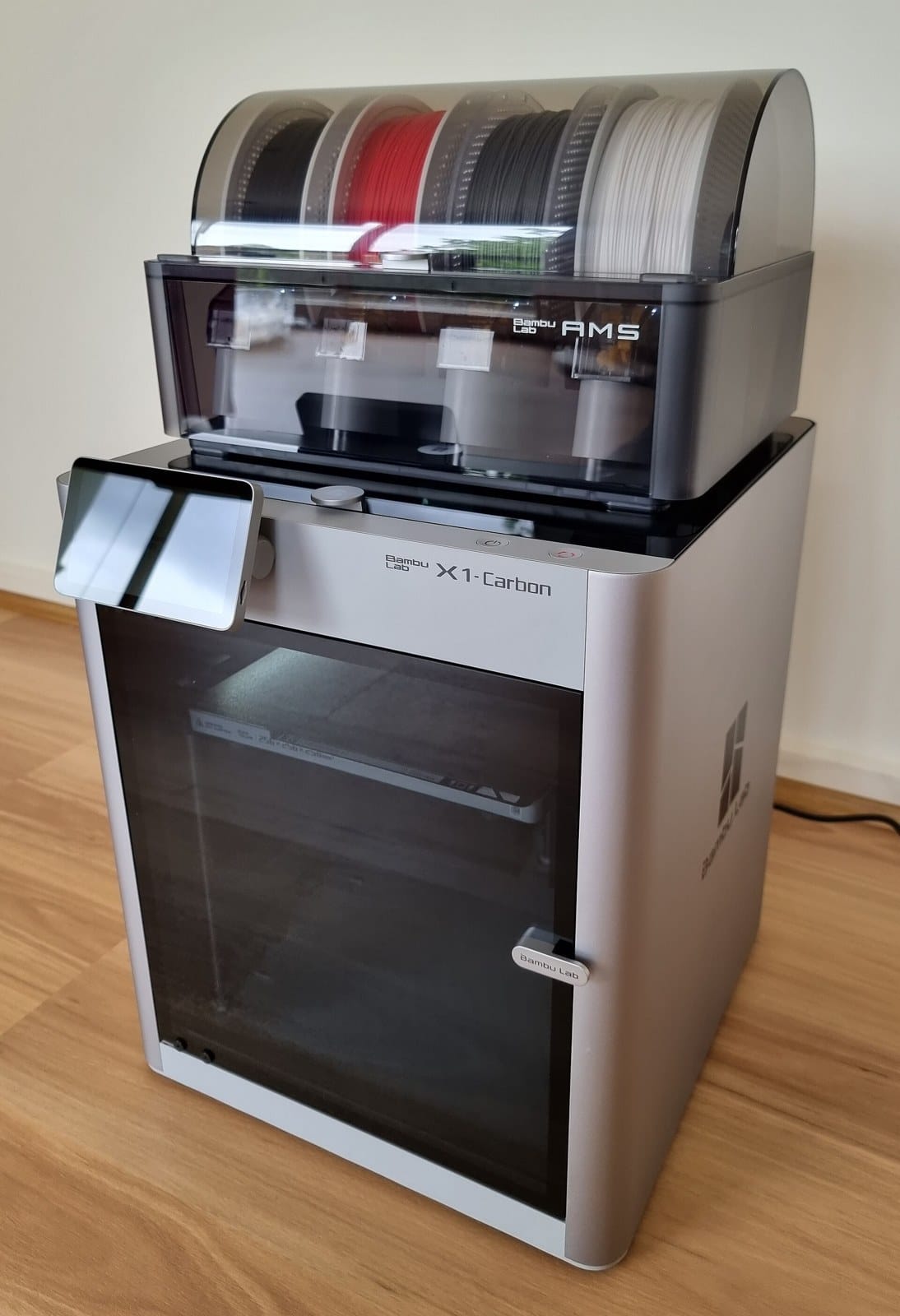 A Bambu Lab X1 Carbon 3D printer with an AMS unit on top